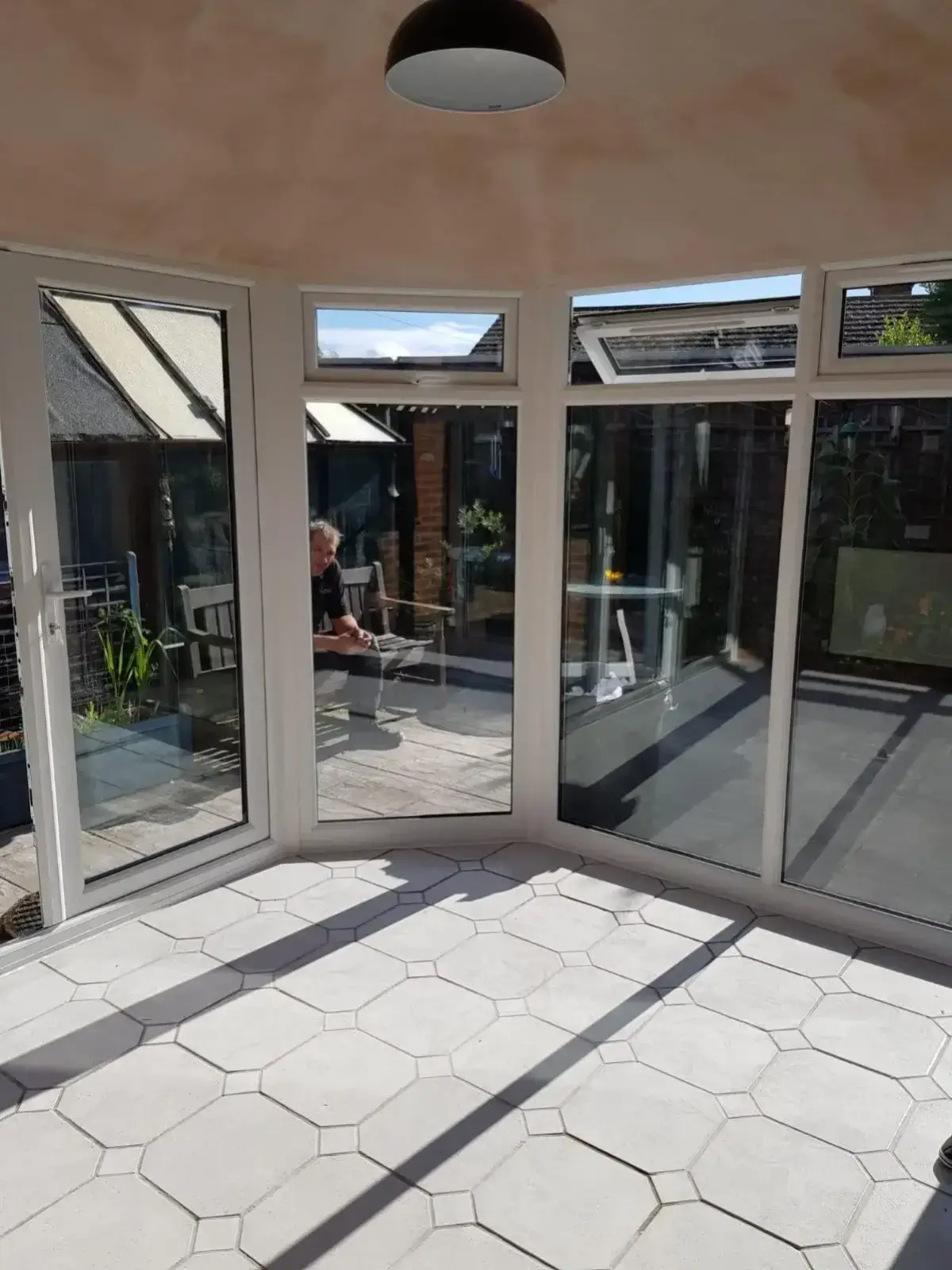 Bright, spacious interior of a completed modern conservatory showing clean tiled flooring and a high vaulted ceiling. By Norfolk Exterior Solutions